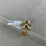A gold ring with a cluster of clear heart-shaped and round stones, displayed on a clear glass rod over a textured light gray background.