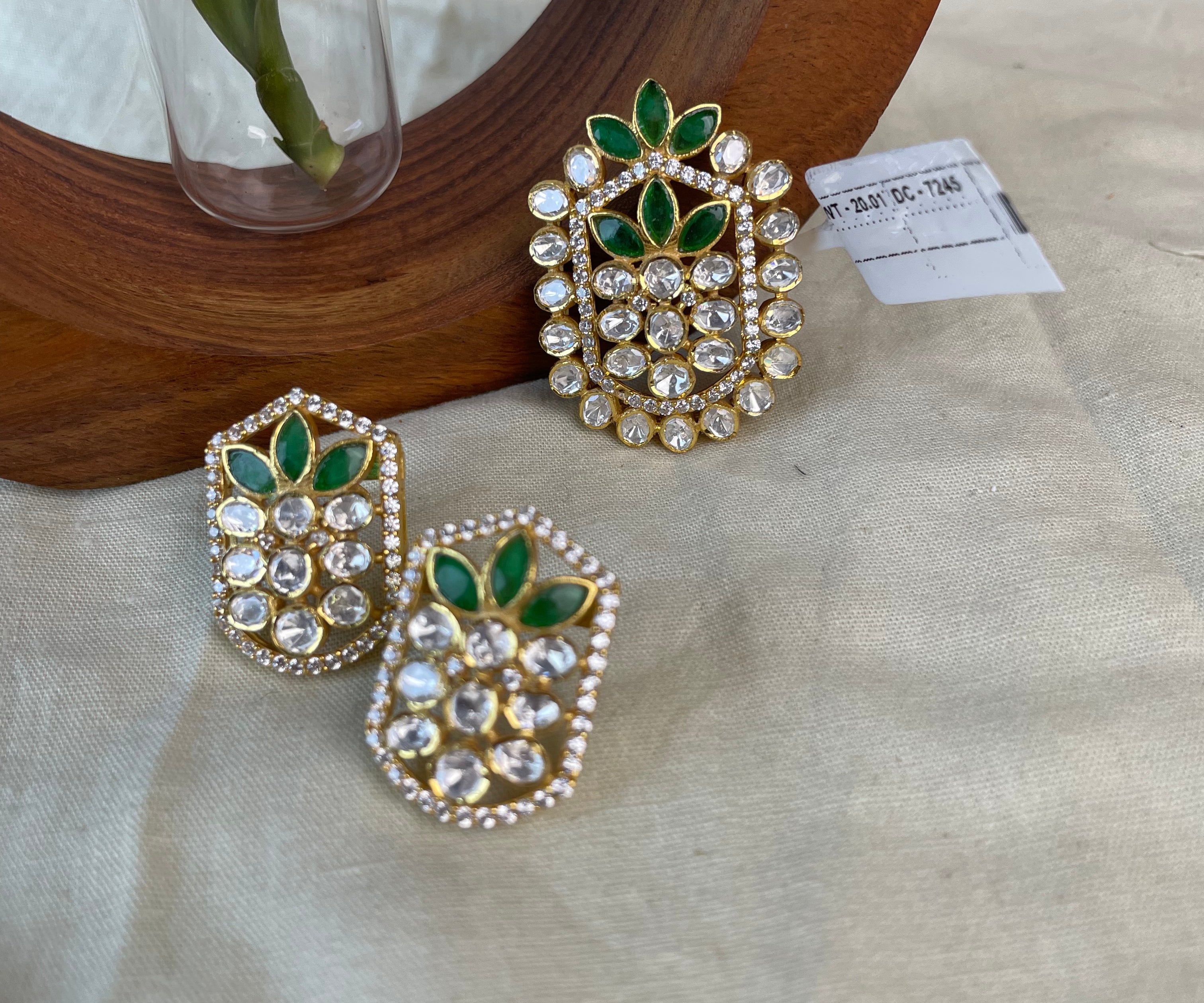 Pallavika Pendant Set with green floral stones, clear stones, and gold-toned detailing.
